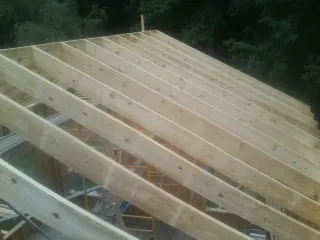 New roof rafters set over an addition before sheathing in Mississippi State
