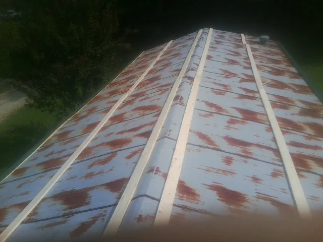 Rusted metal roof panels with new wood purlins before replacement — Storm Damage Roof Repair in Mississippi State by Roofing Brothers