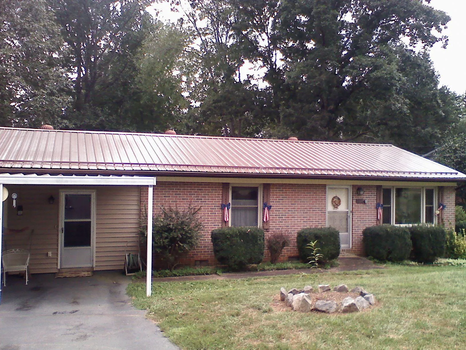 Bronze metal roof and carport on a brick ranch home — Roof Repair work by our crew in Mississippi State